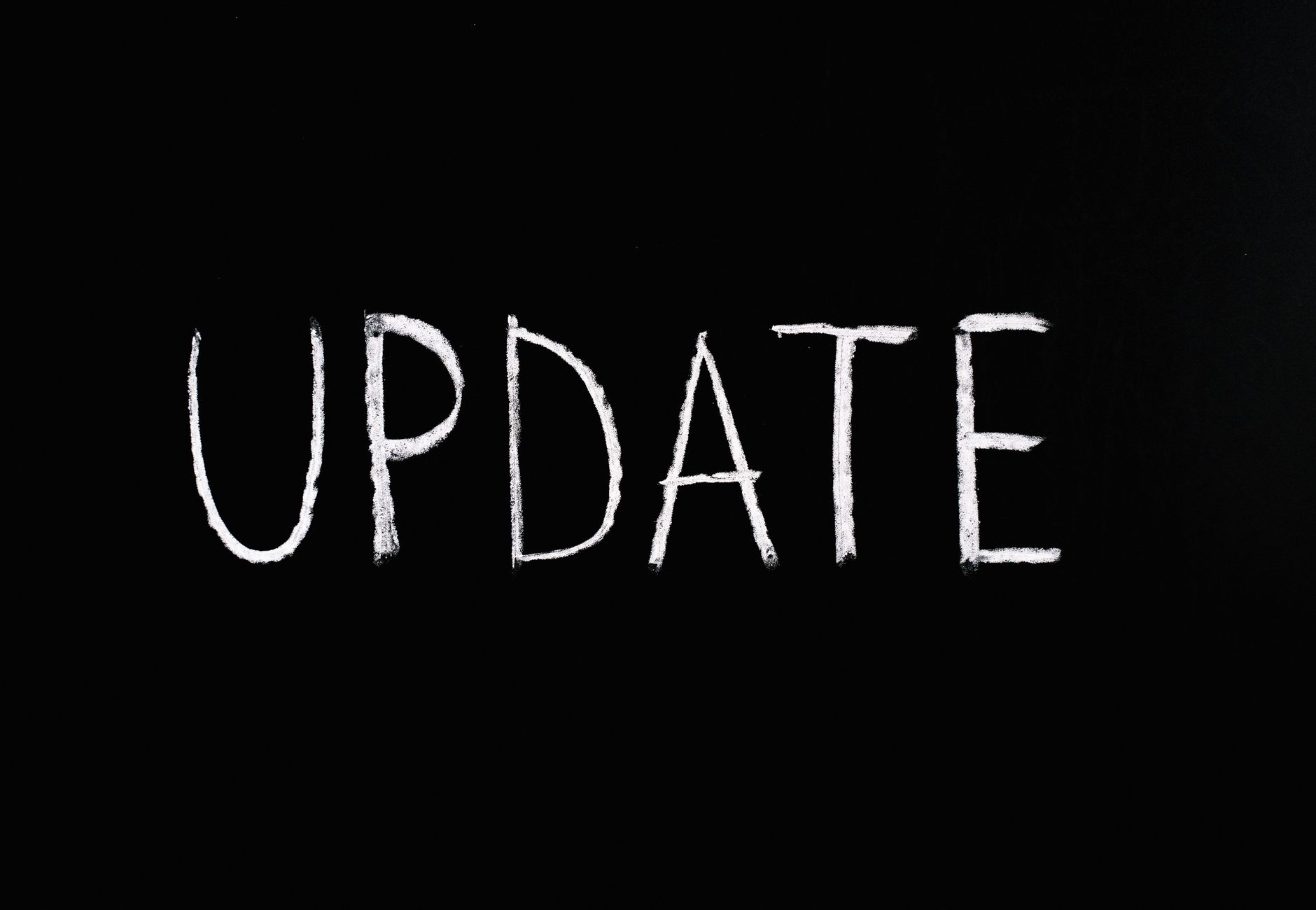 Bold 'UPDATE' text written in chalk on a blackboard. Perfect for concepts of change and communication.